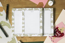 Load image into Gallery viewer, A5 soft coated wheaten terrier notepads designed by Harriet Billingham illustration. Lined and glued along the short edge showing lots of playful wheatens around the edge.