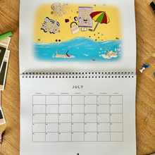 Load image into Gallery viewer, Soft coated wheaten terrier calendar showing the inside month of July. Where the dogs are playing on the beach.
