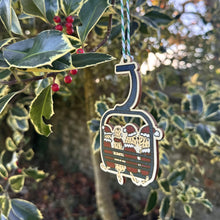 Load image into Gallery viewer, Metallic ski lift chair ornament hanging from a tree with green leaves and red berries.