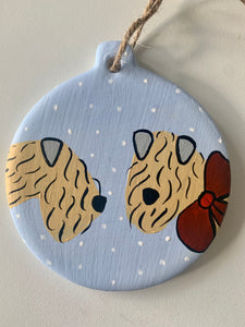 soft coated wheaten Terrier Christmas decoration in the snow on a white back ground