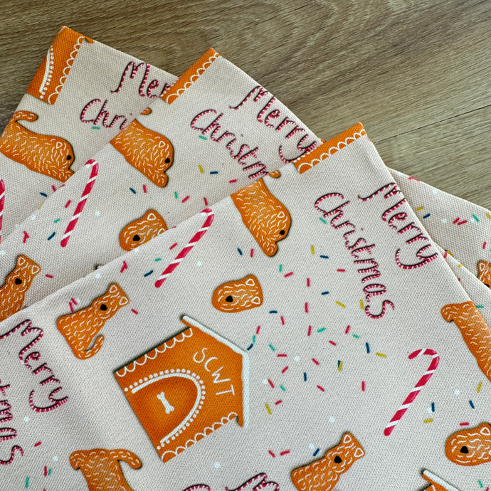 close up of the new soft coated wheaten terrier gingerbread Christmas tea towel. 