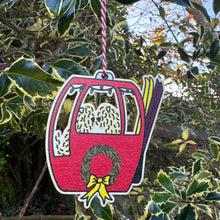 Load image into Gallery viewer, christmas decoration in the shape of a gondola with two soft coated wheaten terriers in. Two sets of skis. Wreath on front. 
