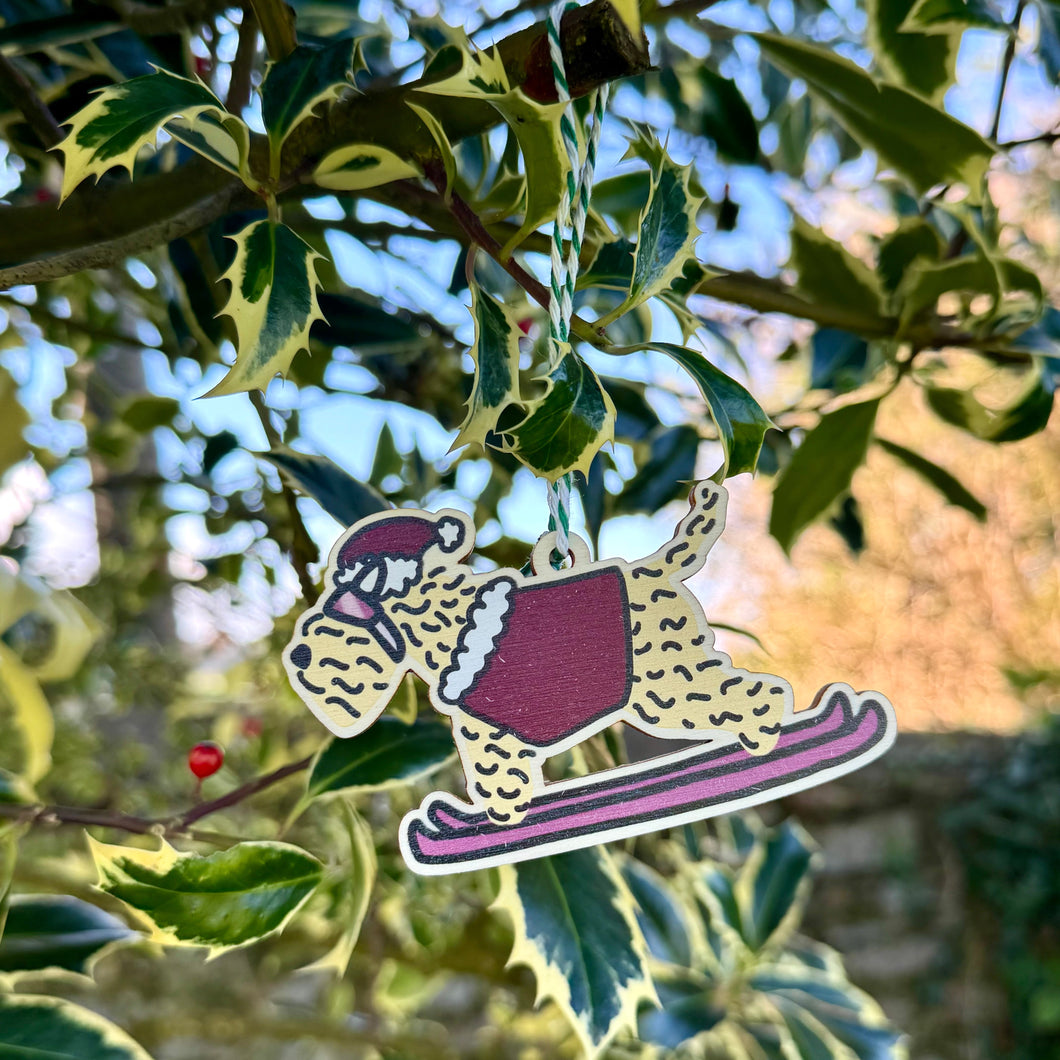 Soft Coated Wheaten Terrier Skiing Christmas decoration. Wearing a festive outfit and on skis.